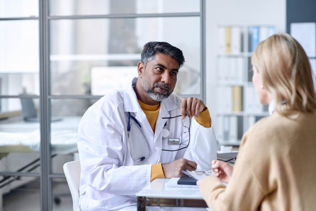 a male doctor talking to his patient referring to a Psychiatrist